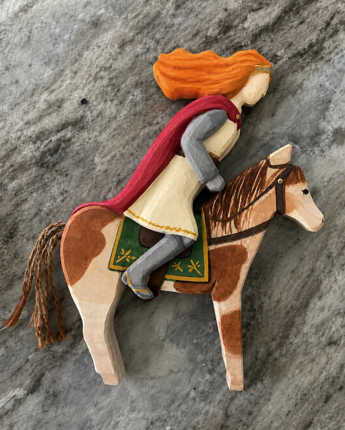 Hand-painted wooden rider with crimson cape on chestnut horse